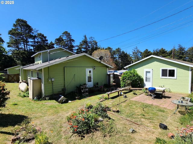 back of house featuring a patio and a lawn