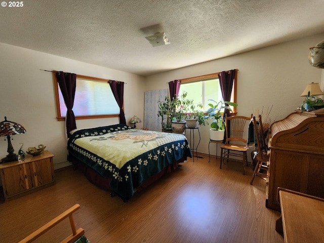 bedroom with a textured ceiling and wood finished floors
