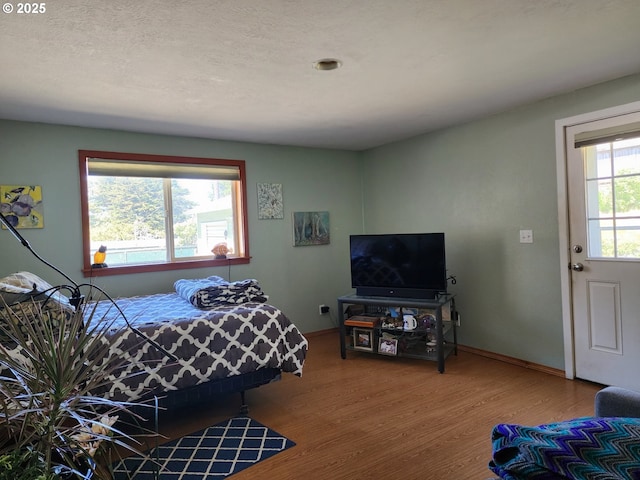 bedroom featuring wood finished floors and baseboards