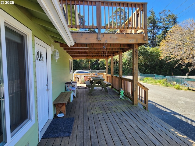 deck featuring outdoor dining area and fence