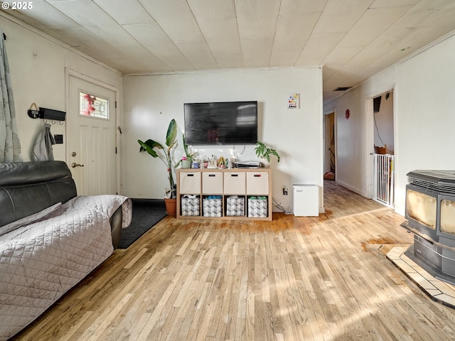 living room with light hardwood / wood-style flooring and a wood stove