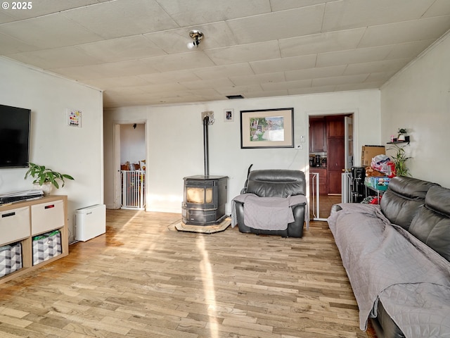 living room with light wood-type flooring and a wood stove