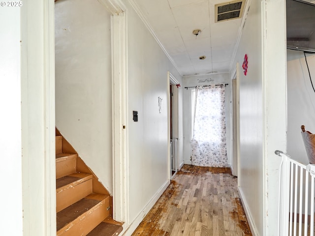 hall with light wood-type flooring and ornamental molding