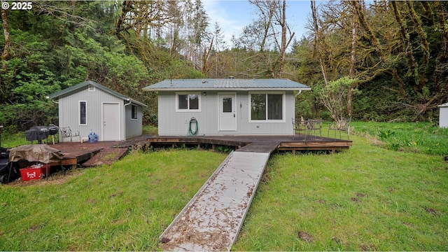 1298 N Tenmile, Lakeside, OR 97449 - rear view of property featuring a yard, a wooden deck, an outdoor structure, and metal roof