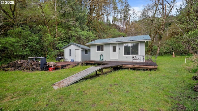 1298 N Tenmile, Lakeside, OR 97449 - back of property featuring a yard, metal roof, a wooden deck, and an outdoor structure