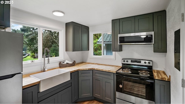1298 N Tenmile, Lakeside, OR 97449 - kitchen featuring butcher block countertops, a sink, and stainless steel appliances