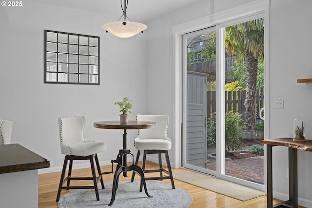 dining area featuring light wood-type flooring and baseboards