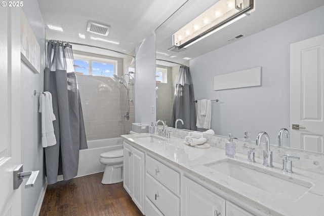 bathroom with visible vents, a sink, wood finished floors, and toilet
