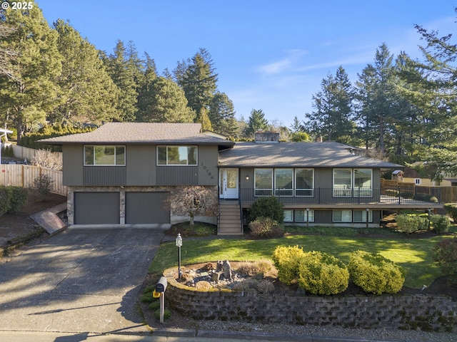 split level home featuring a garage and a front lawn