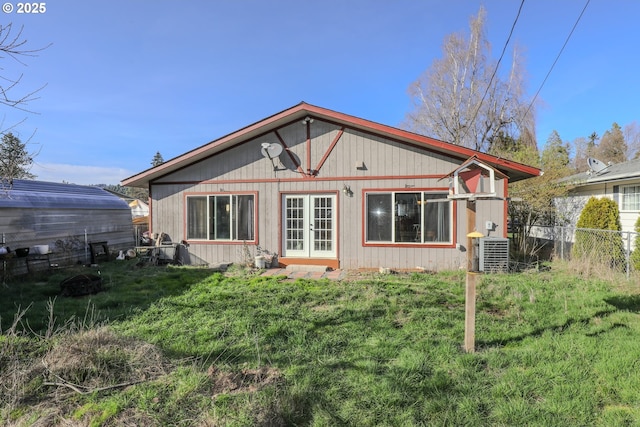 rear view of house featuring a yard, french doors, central AC, and fence