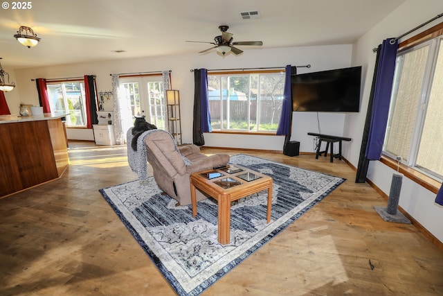 living area featuring visible vents, french doors, baseboards, and wood finished floors