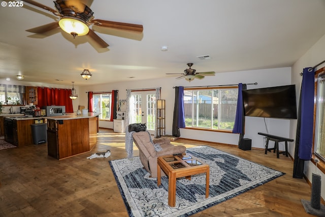 living room featuring dark wood-style floors, visible vents, french doors, and ceiling fan