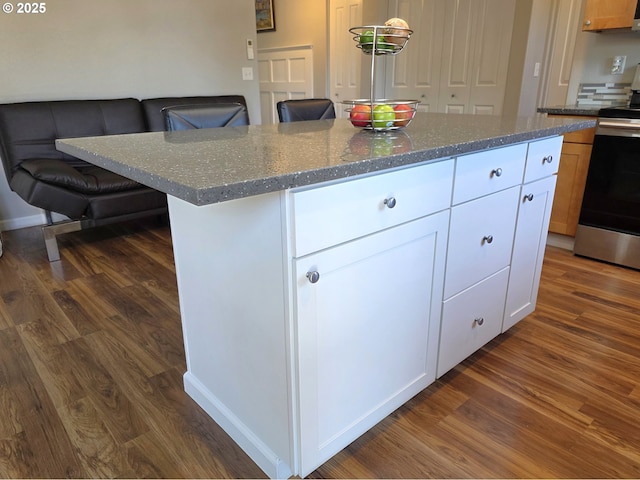 755 Nebraska St, Eugene, OR 97402 - kitchen with dark wood-style flooring, stainless steel range with electric cooktop, white cabinetry, dark stone countertops, and a kitchen island