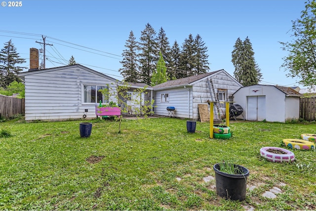 view of yard featuring fence, an outdoor structure, and a storage unit