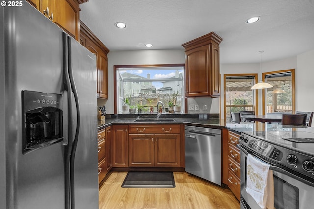 kitchen featuring appliances with stainless steel finishes, light hardwood / wood-style floors, sink, and a wealth of natural light