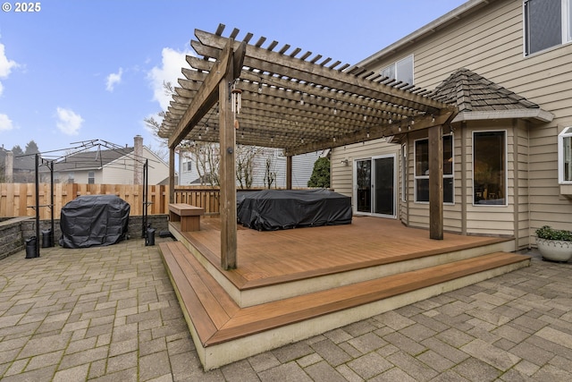 wooden deck featuring a grill, a pergola, and a patio area