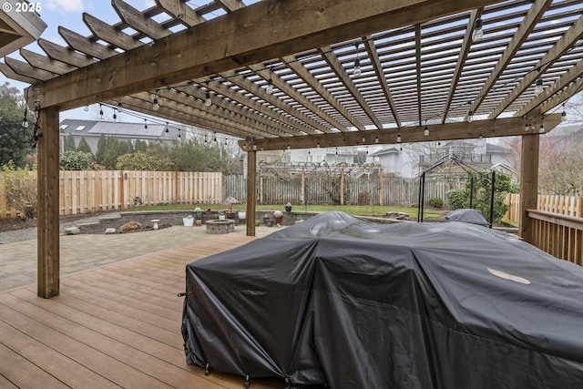 deck with grilling area, an outdoor fire pit, a pergola, and a patio