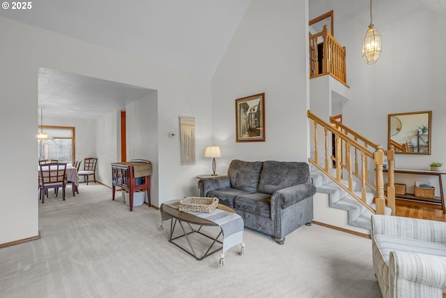 living room featuring carpet flooring, a chandelier, and high vaulted ceiling