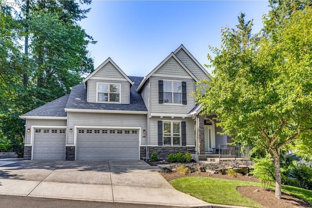 865 SW Trillium Ln, Portland, OR 97219 - craftsman house featuring stone siding, concrete driveway, roof with shingles, covered porch, and a garage