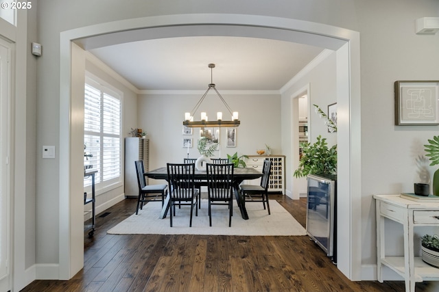 865 SW Trillium Ln, Portland, OR 97219 - dining space with a chandelier, beverage cooler, crown molding, and dark wood-style floors