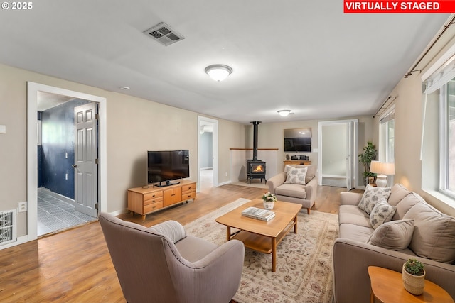 living room featuring a wood stove and light hardwood / wood-style floors