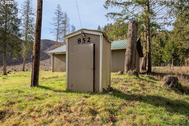 view of outdoor structure featuring a mountain view and a lawn