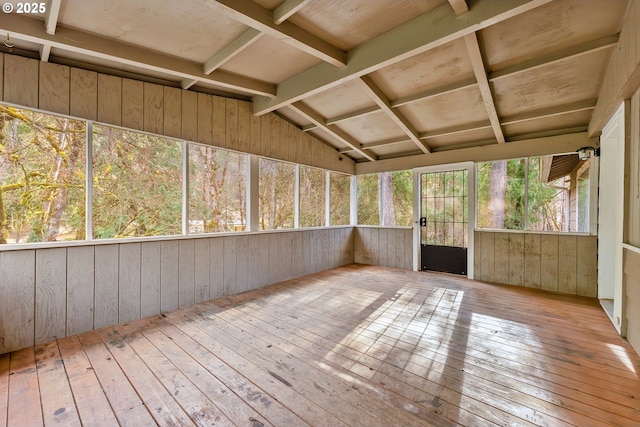 unfurnished sunroom featuring vaulted ceiling