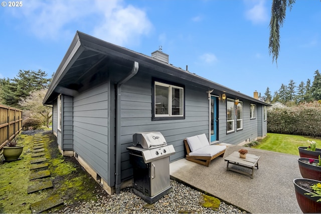 back of property featuring a yard, a chimney, a patio, and fence