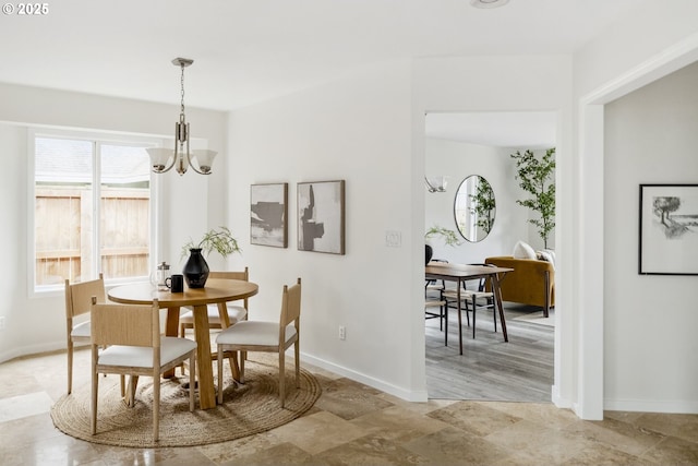 dining space with a notable chandelier and baseboards