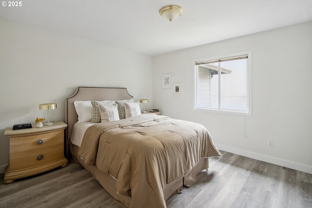 bedroom featuring baseboards and wood finished floors