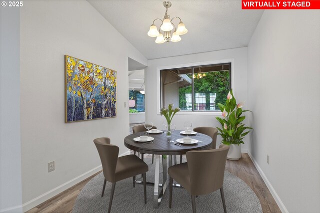 dining room with baseboards, wood finished floors, and a notable chandelier