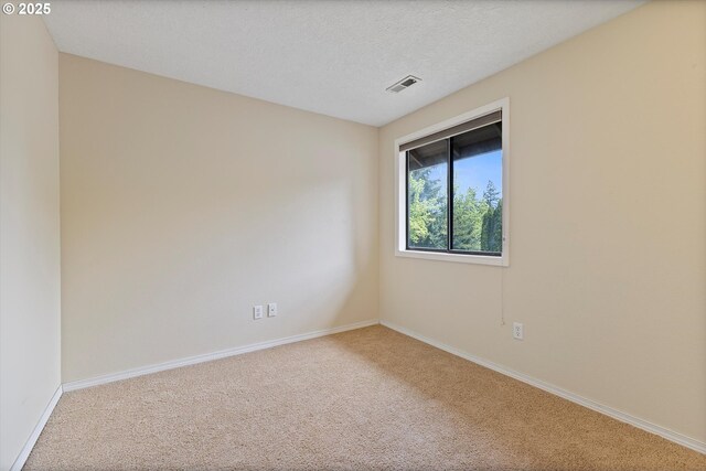 unfurnished room with carpet floors, baseboards, and visible vents