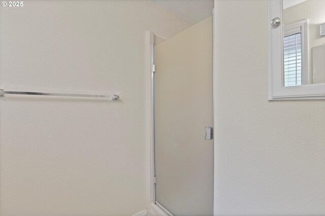 bathroom featuring a shower with door