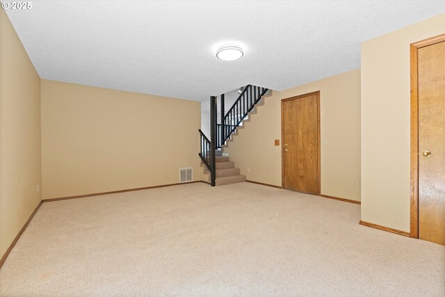 interior space with carpet floors, visible vents, and stairs