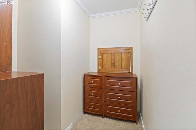 interior space with baseboards, ornamental molding, and light colored carpet