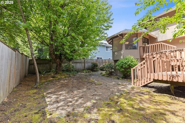 view of yard with a sunroom, a fenced backyard, stairway, and a deck