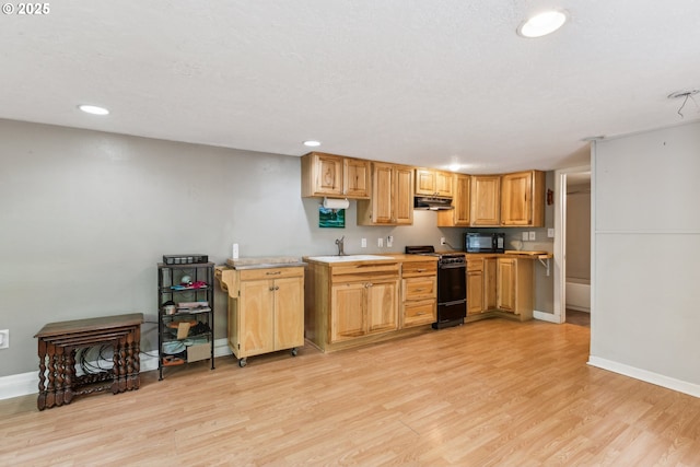 4315 NE 90th Ave, Portland, OR 97220 - kitchen with black appliances, under cabinet range hood, light wood finished floors, baseboards, and recessed lighting