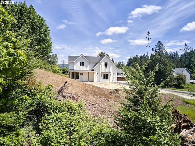 117 Witherbee Rd, Kelso, WA 98626 - modern farmhouse with board and batten siding, dirt driveway, and a patio