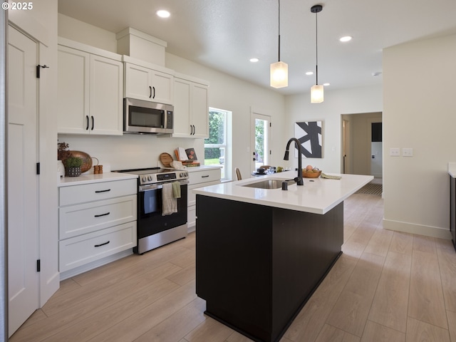 117 Witherbee Rd, Kelso, WA 98626 - kitchen with stainless steel appliances, a sink, light countertops, a center island with sink, and white cabinets