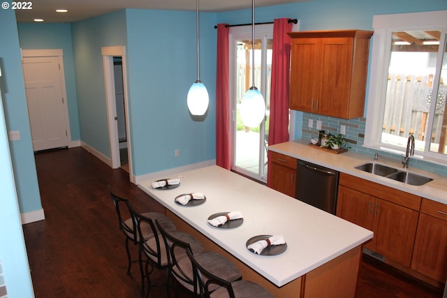 2917 SW 198th Ave, Beaverton, OR 97003 - kitchen with stainless steel dishwasher, brown cabinets, light countertops, a breakfast bar, and backsplash