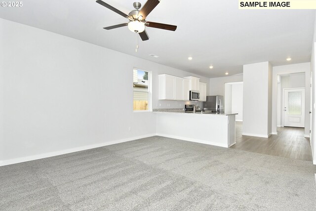 unfurnished living room with baseboards, recessed lighting, ceiling fan, and carpet floors