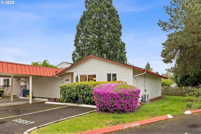 view of front of home featuring a front lawn, uncovered parking, and fence