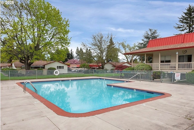 pool with a patio and fence