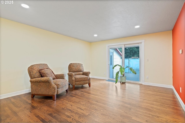 sitting room featuring baseboards, recessed lighting, and wood finished floors