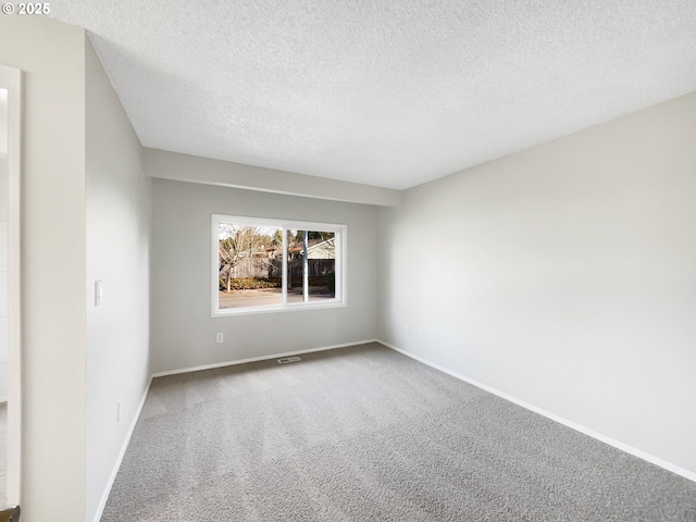 unfurnished bedroom with a textured ceiling, carpet, a closet, and baseboards