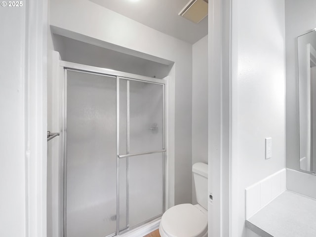 bathroom featuring a shower stall and toilet