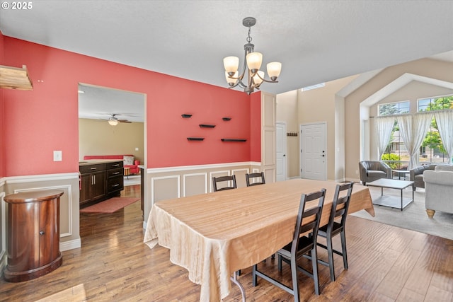 702 SW Burlingame Cir, Troutdale, OR 97060 - dining space with a wainscoted wall, wood finished floors, a chandelier, a decorative wall, and ceiling fan