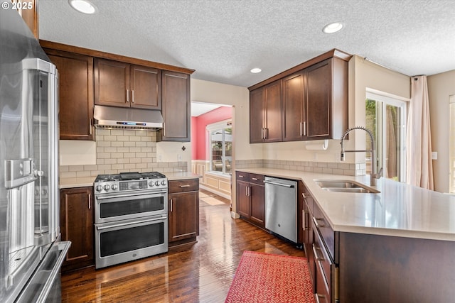 702 SW Burlingame Cir, Troutdale, OR 97060 - kitchen featuring stainless steel appliances, under cabinet range hood, light countertops, a textured ceiling, and tasteful backsplash