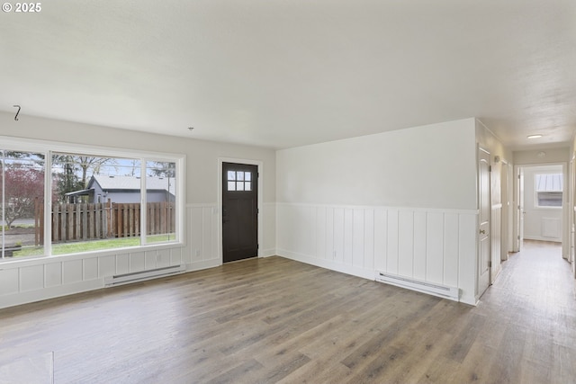 53112 NW Manor Dr, Scappoose, OR 97056 - interior space featuring baseboard heating, wood finished floors, a baseboard heating unit, and a wainscoted wall