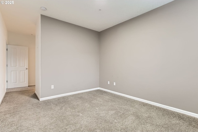 unfurnished room with carpet flooring and baseboards
